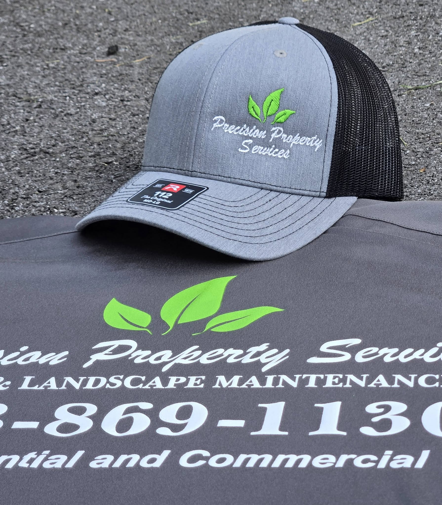 silver and black embroidered hat with green and white lawncare logo
