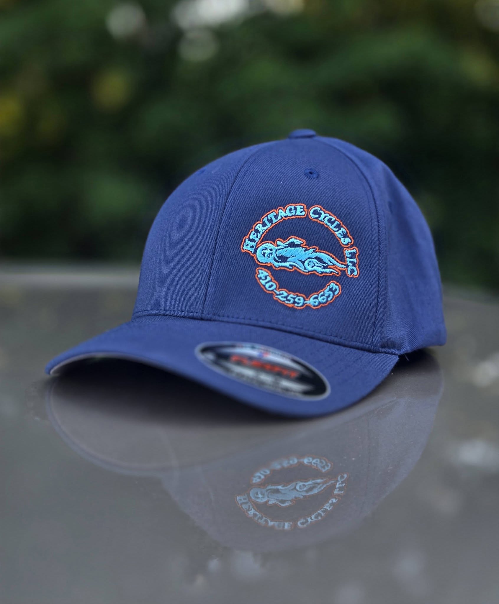 navy hat with orange and teal motorcycle repair logo