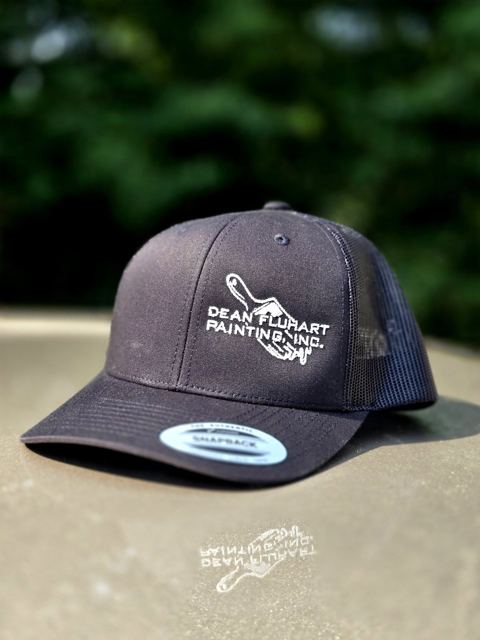 black embroidered hat with white painting services logo